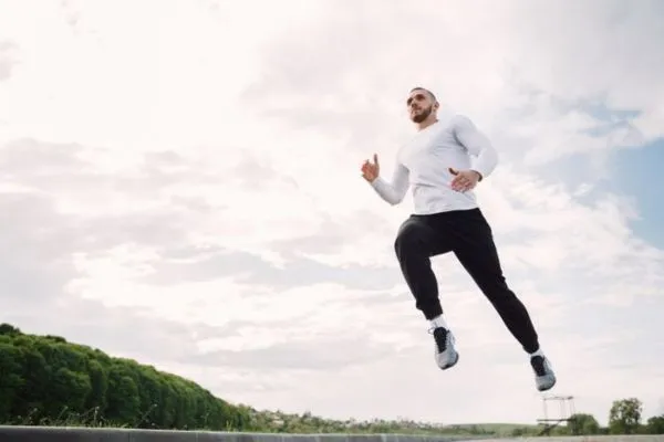 Active fit man jumping outdoors representing physical stamina and vitality associated with nitric oxide support